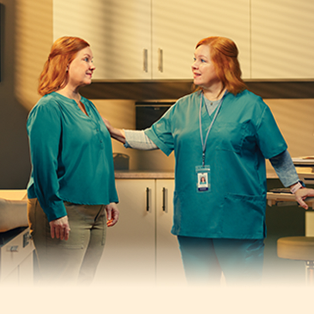 Female nurse talking to patient in exam room